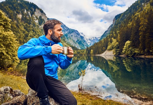 Solo healthcare traveler in the mountains by a lake