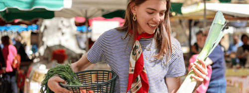 Woman holding a basket at a farmers market