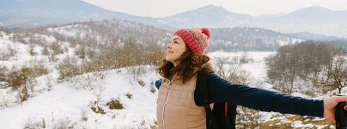 Woman with her hands out standing in a snowy scenery