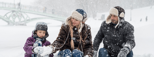 Family of 3 sitting in the snow