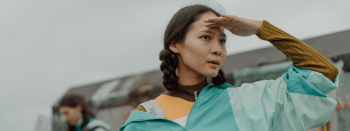 Woman with her hand on her forehead looking out into the distance