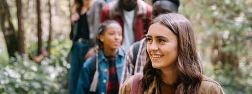Group of friends hiking on a trail in a forest