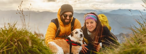 Couple adventuring with their dog and hiking gear