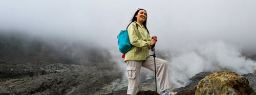Woman standing in rocky scenery with hiking gear