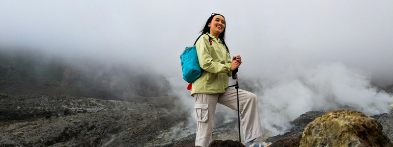 Woman standing in rocky scenery with hiking gear