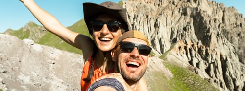 Couple taking a selfie together with scenic rocky mountains in the background