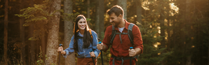 Couple walking through a forest with hiking gear