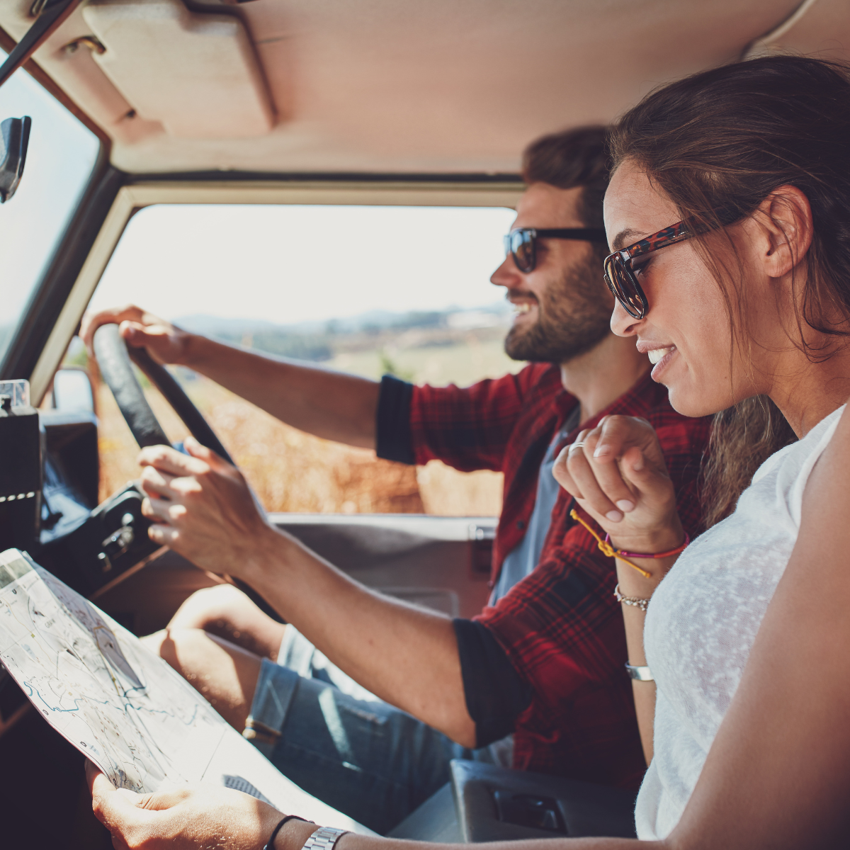 Couple reading a map while in a car on a road trip
