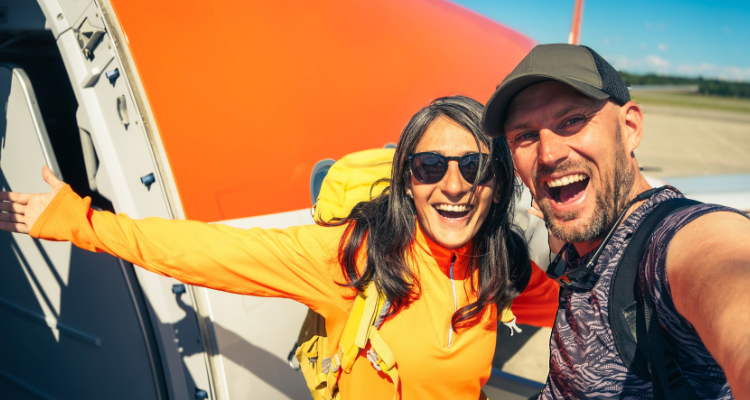 Couple taking a selfie in front of an airplane