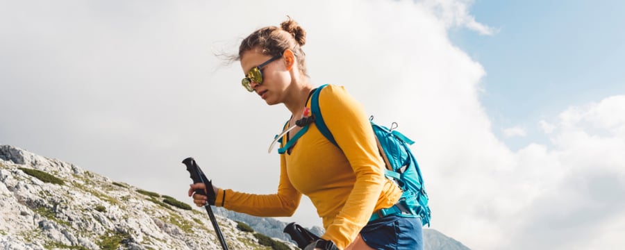 Woman in hiking gear walking through a mountain