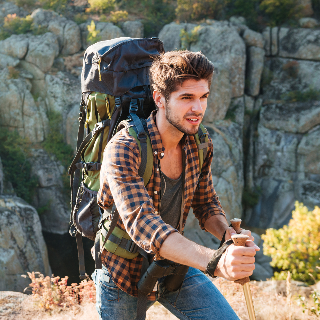 Man with a backpack hiking through rocks