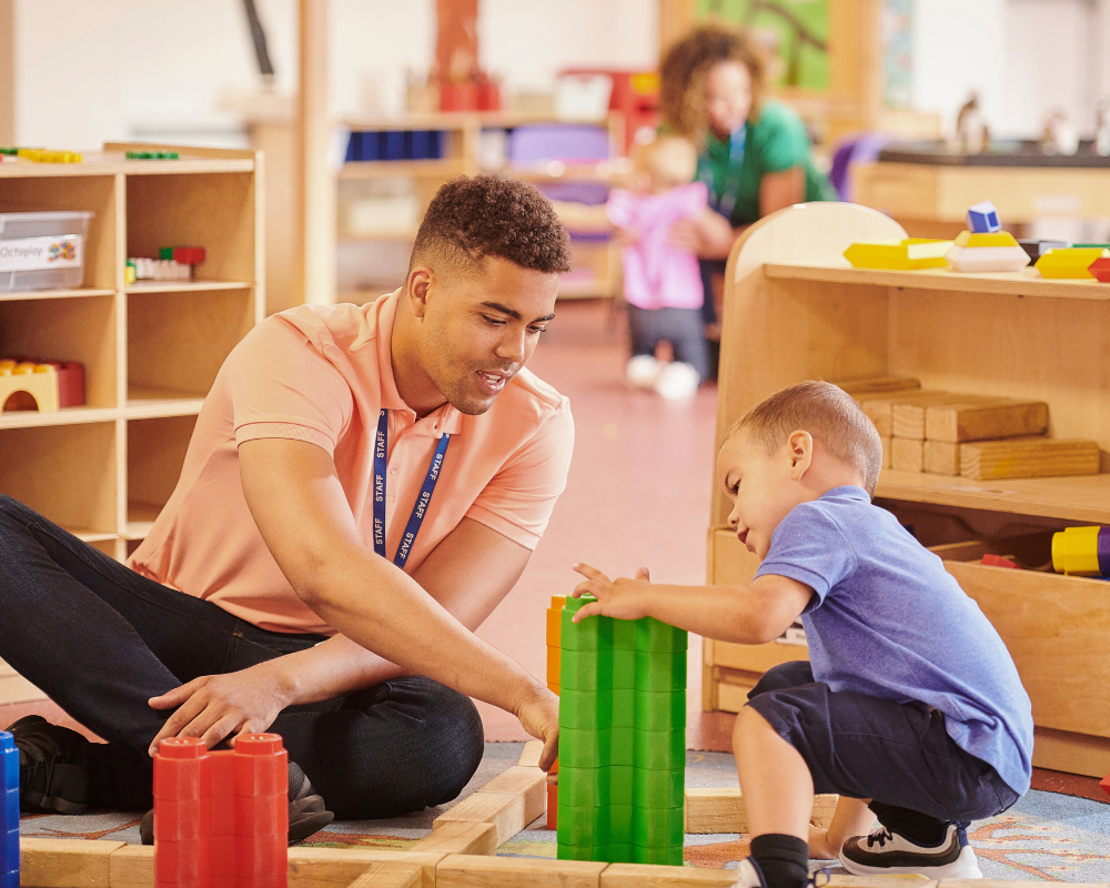 Teacher helping a student build blocks