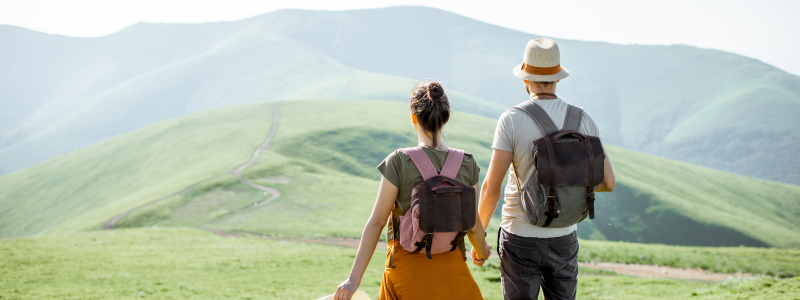 Couple holding hands and walking through a mountain range together
