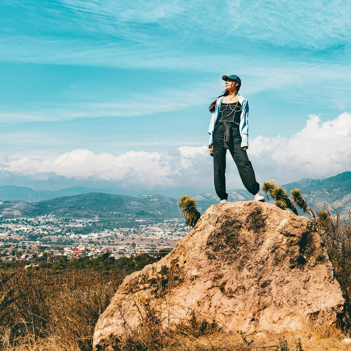 Woman standing on a rock with a beautiful scenery behind her