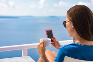 Woman on phone with a cup of coffee in hand