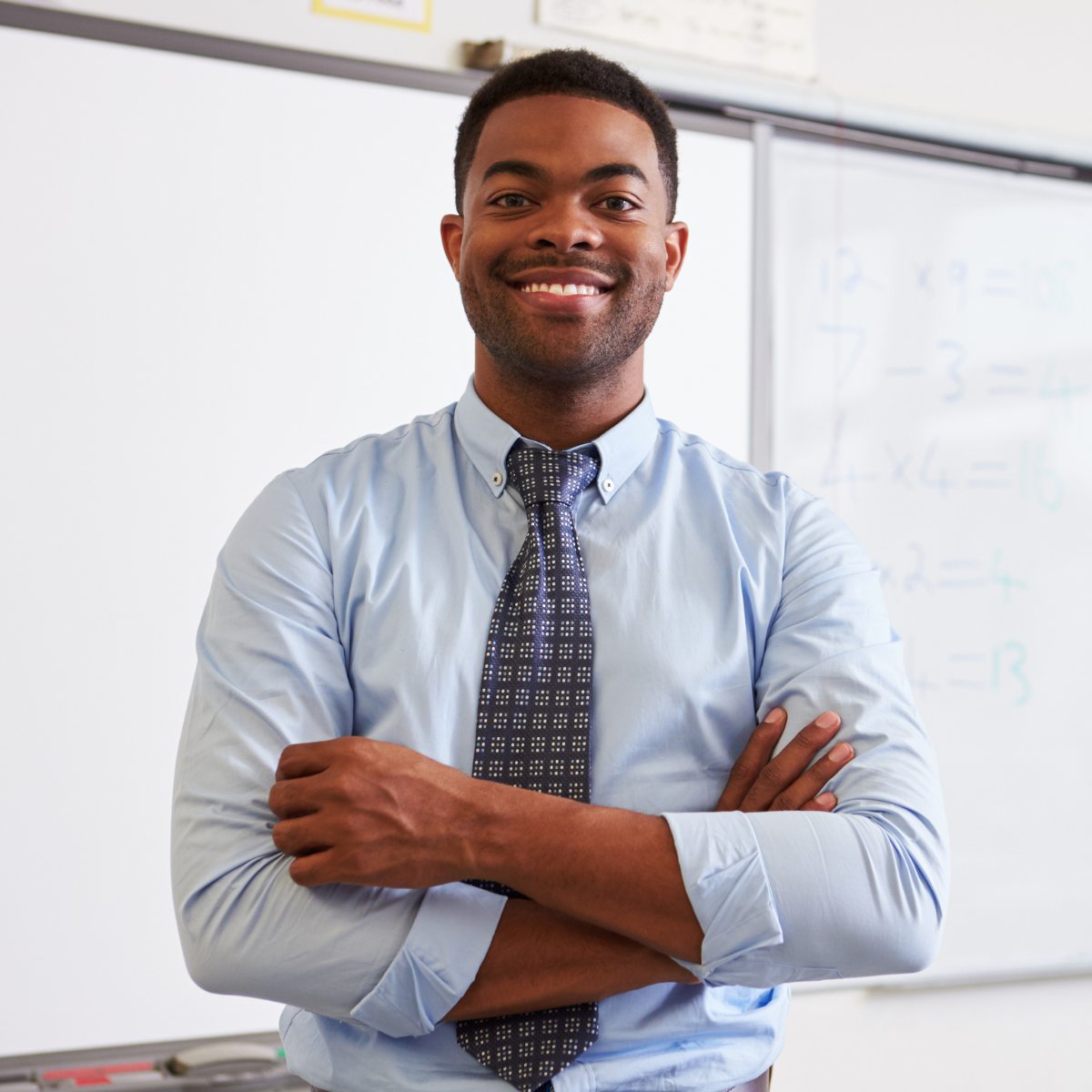 teacher with his arms crossed and smiling
