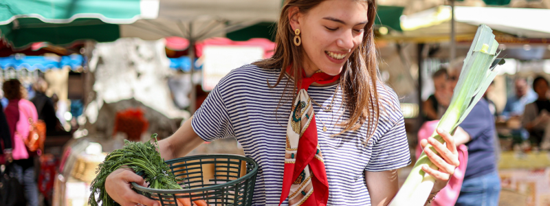 Woman holding a basket at a farmers market
