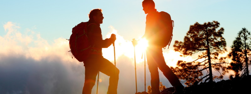 Silhouette of a couple hiking in a mountain range 