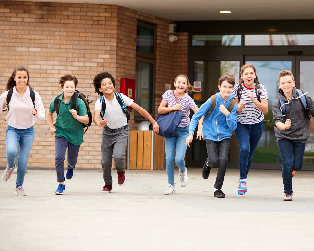 Group of middle school kids running out of school