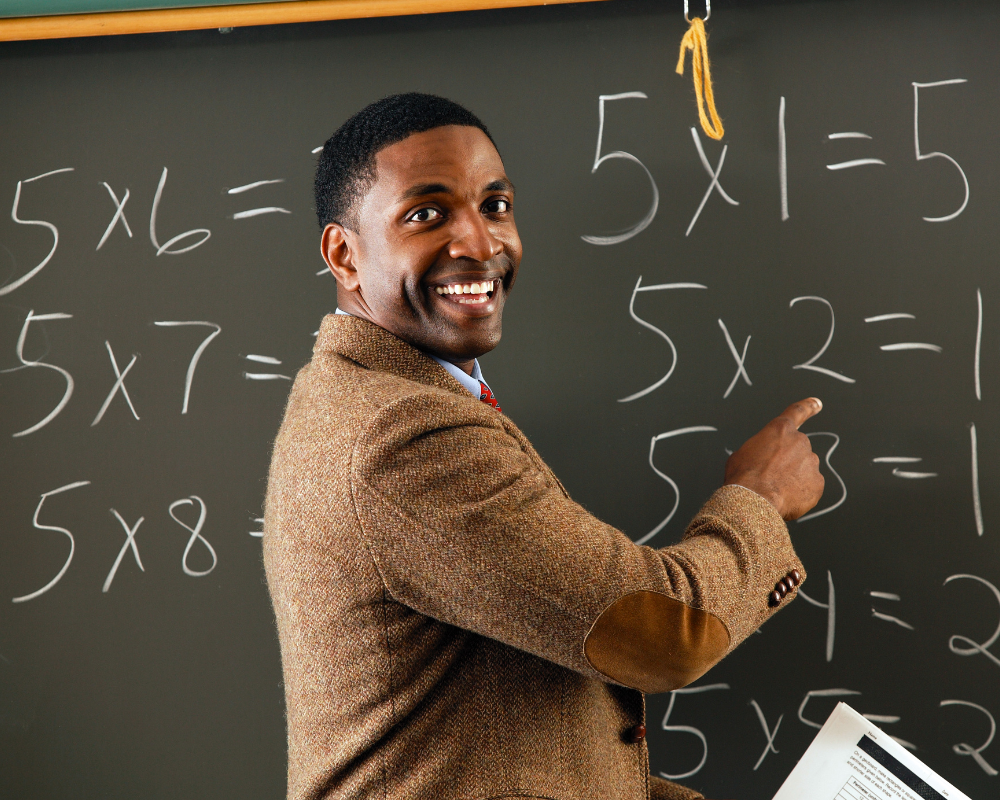 Male teacher writing on a chalkboard