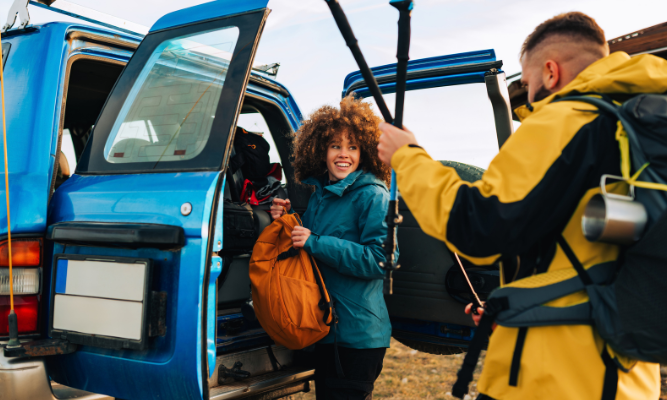 People loading hiking gear into a car
